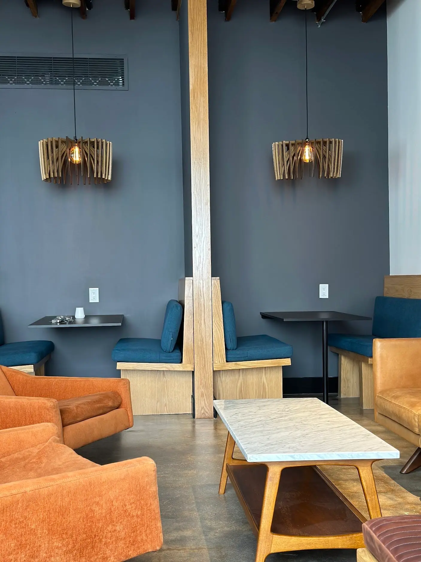 Booth seating and lounge chairs under wood pendant lights